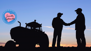 Miehet kättelevät toisiaan pellolla ilta-auringossa. Taustalla traktori.